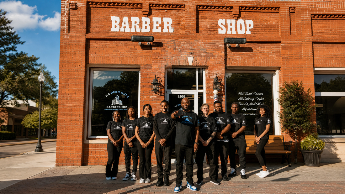 Modern Cuts Barbershop team standing outside their brick storefront in Hiram, GA, beneath the large “BARBER SHOP” sign.